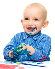 Image showing Little boy is playing with paints