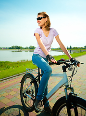 Image showing Young woman is sitting on her bicycle