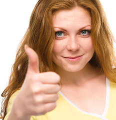 Image showing Woman is showing thumb up gesture