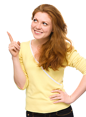 Image showing Portrait of a young woman pointing to the left