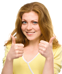 Image showing Woman is showing thumb up gesture