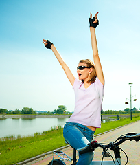 Image showing Young woman is sitting on her bicycle