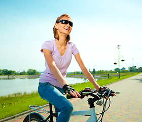 Image showing Young woman is sitting on her bicycle