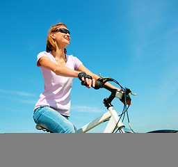 Image showing Young woman is sitting on her bicycle