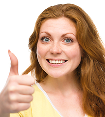 Image showing Woman is showing thumb up gesture