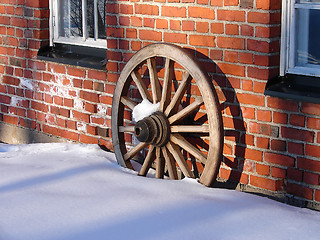 Image showing Wooden wheel and brick wall