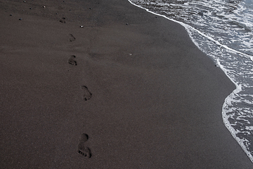 Image showing foot prints on black sand