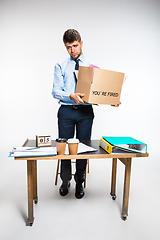 Image showing The young man is resigned and folds things in the workplace