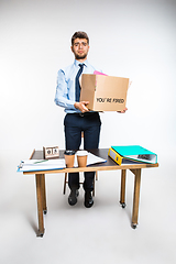 Image showing The young man is resigned and folds things in the workplace