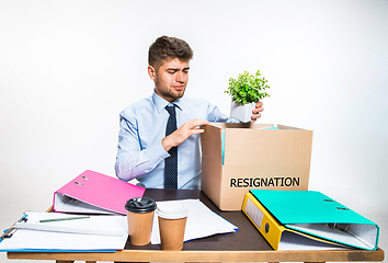 Image showing The young man is resigned and folds things in the workplace