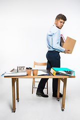Image showing The young man is resigned and folds things in the workplace