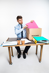 Image showing The young man is resigned and folds things in the workplace