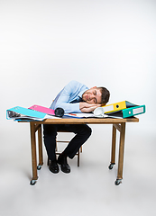 Image showing The young man is brazenly sleeping on the desktop during his working hours