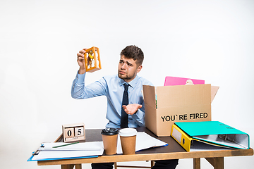 Image showing The young man is resigned and folds things in the workplace