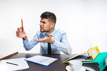 Image showing The ink in the pen ended abruptly and the man is forced to write in pencil