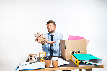 Image showing The young man is resigned and folds things in the workplace