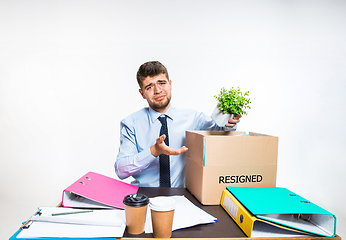 Image showing The young man is resigned and folds things in the workplace