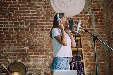 Image showing Woman recording music, broadcasting and singing at home