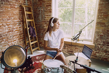 Image showing Woman recording music, playing drums and singing at home