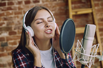 Image showing Woman recording music, broadcasting and singing at home