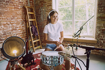 Image showing Woman recording music, playing drums and singing at home