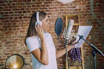 Image showing Woman recording music, broadcasting and singing at home