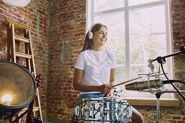 Image showing Woman recording music, playing drums and singing at home