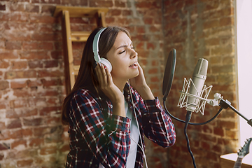 Image showing Woman recording music, broadcasting and singing at home