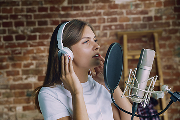 Image showing Woman recording music, broadcasting and singing at home