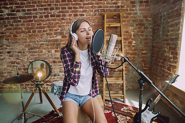 Image showing Woman recording music, broadcasting and singing at home