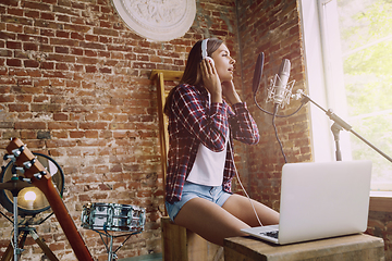 Image showing Woman recording music, broadcasting and singing at home