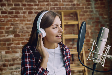 Image showing Woman recording music, broadcasting and singing at home