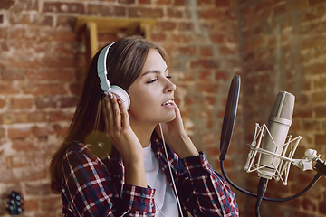 Image showing Woman recording music, broadcasting and singing at home