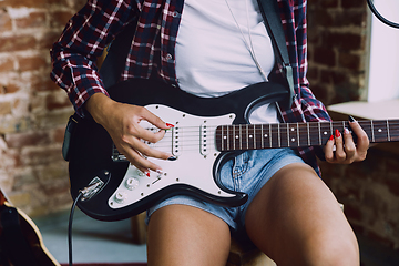 Image showing Woman recording music, playing guitar and singing at home