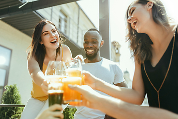 Image showing Young group of friends drinking beer and celebrating together