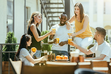 Image showing Young group of friends drinking beer and celebrating together