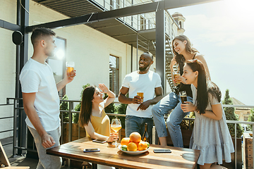 Image showing Young group of friends drinking beer and celebrating together