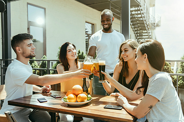 Image showing Young group of friends drinking beer and celebrating together