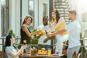 Image showing Young group of friends drinking beer and celebrating together