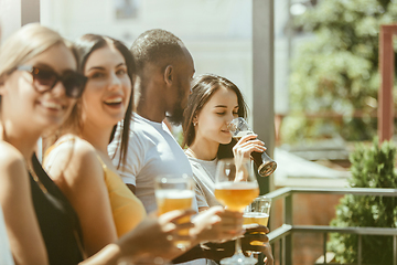 Image showing Young group of friends drinking beer and celebrating together