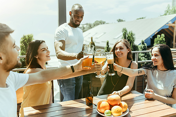 Image showing Young group of friends drinking beer and celebrating together