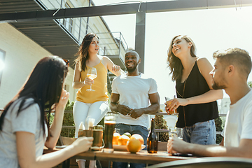 Image showing Young group of friends drinking beer and celebrating together