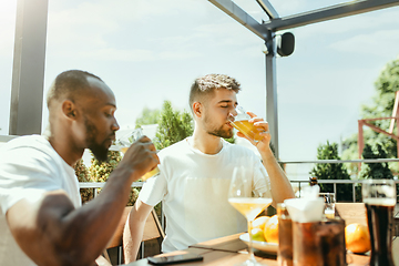 Image showing Young men drinking beer and celebrating together