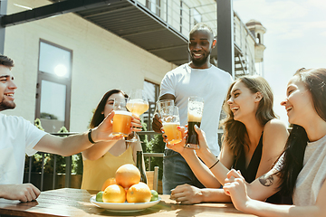 Image showing Young group of friends drinking beer and celebrating together