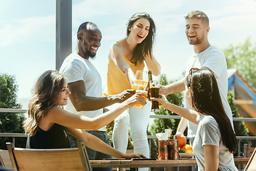 Image showing Young group of friends drinking beer and celebrating together