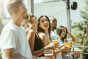 Image showing Young group of friends drinking beer and celebrating together