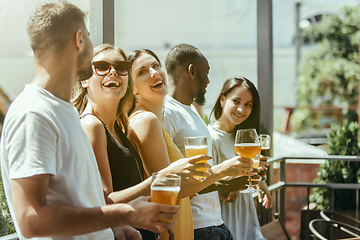 Image showing Young group of friends drinking beer and celebrating together