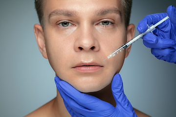 Image showing Close-up portrait of young man isolated on grey studio background