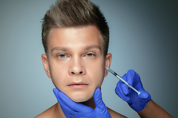 Image showing Close-up portrait of young man isolated on grey studio background