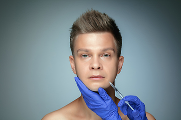 Image showing Close-up portrait of young man isolated on grey studio background